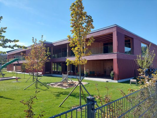 Über die Grenze geht es zum Kindergarten Mattsee, der in 4 Gruppen in Holzbauweise errichtet wurde.